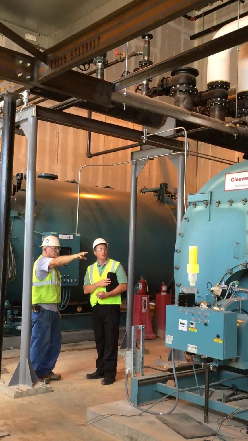 Two workers in boiler room